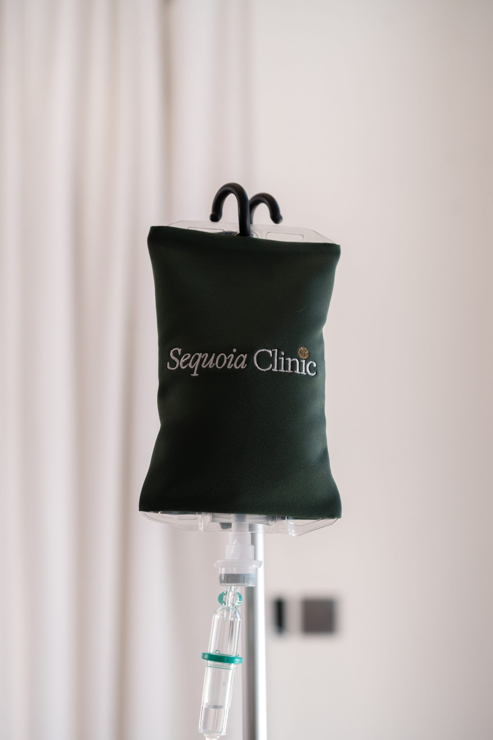 A green IV bag cover printed with the Sequoia Clinic wordmark