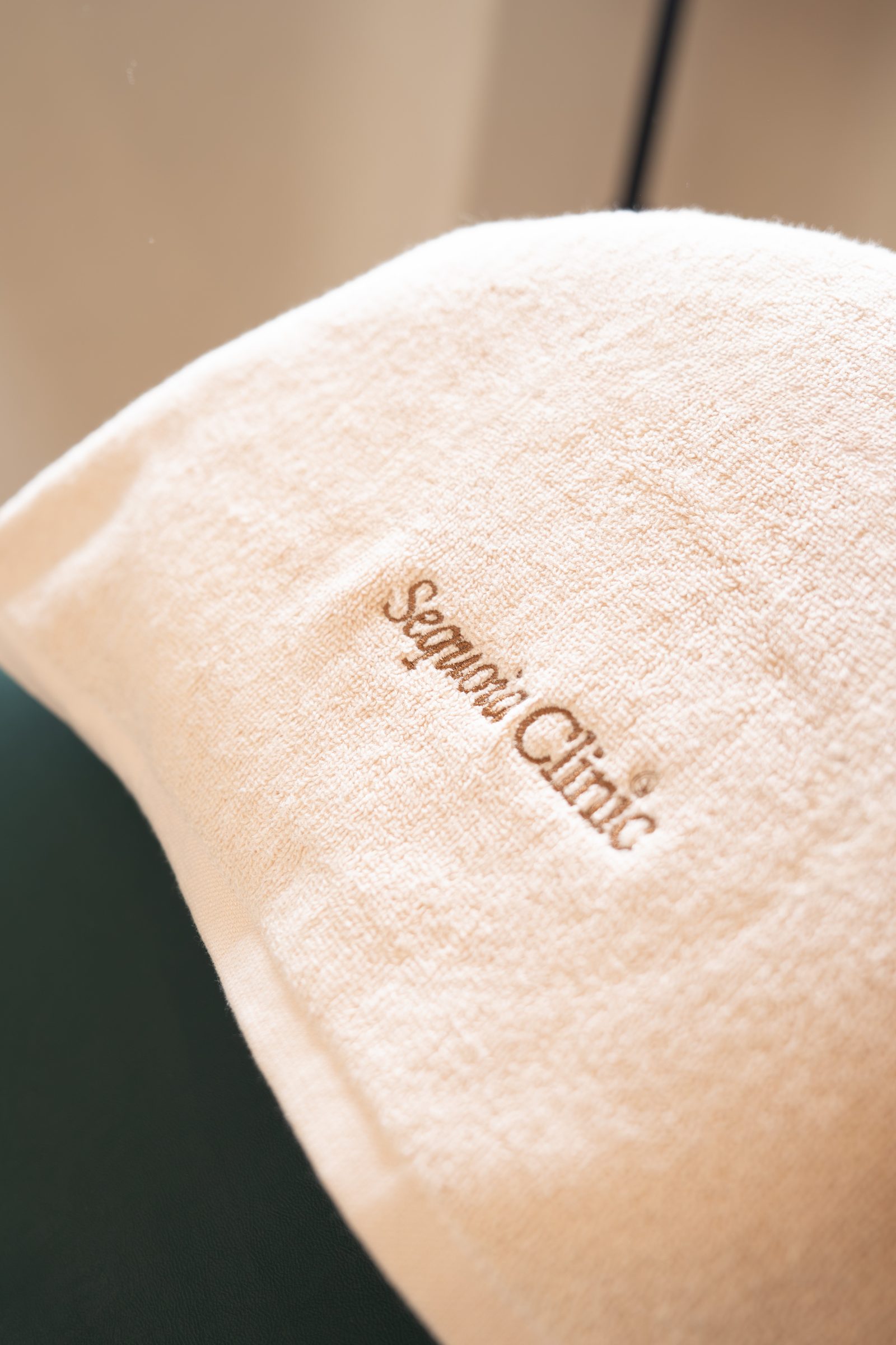 A cream towel embroidered with the Sequoia Clinic wordmark